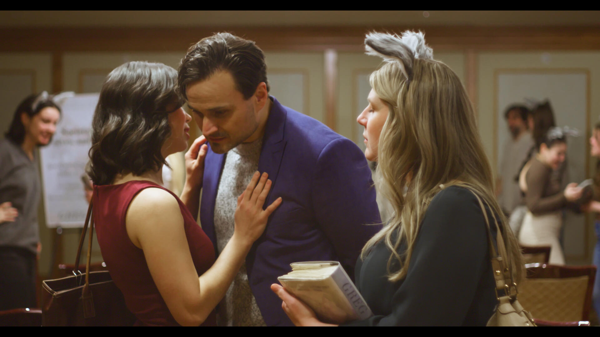 The protagonist of Method & Madness watches the antagonist and a teammate speaking discreetly.