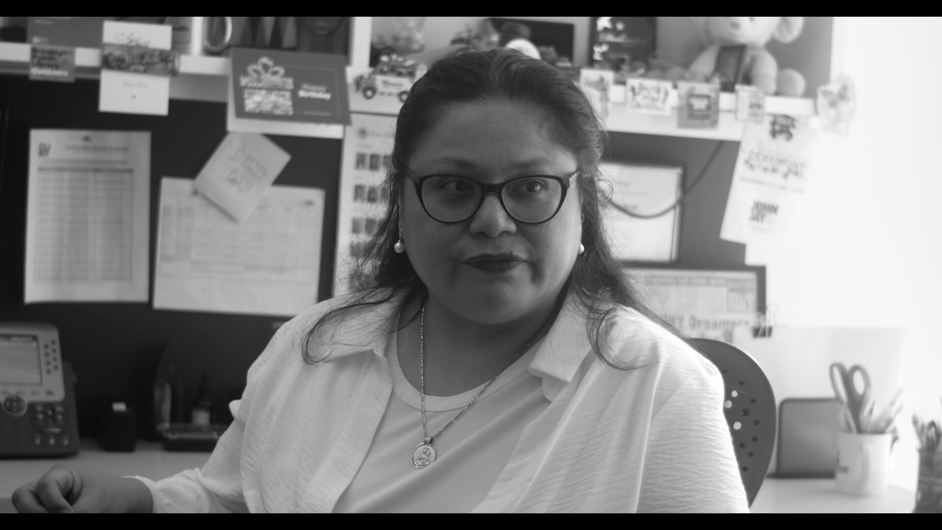 Invited to Leave Still 3 Alicia Arana, Esquire, sits in her office, illuminated on the side by sunlight coming in through the window.